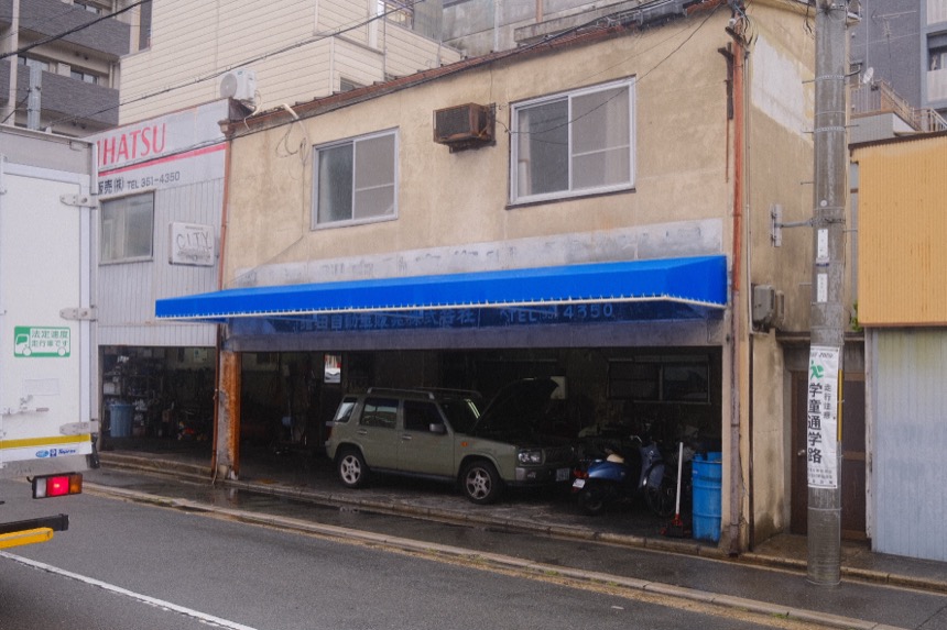 A quiet Japanese street corner with a blue awning